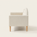 Side studio | Right-side profile of the cream textured loveseat showing its square arm, high arched back, and tapered brown legs