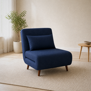 Room 1 angle | navy blue plain-weave armless convertible chair in the warm white room at a strong front-left three-quarter angle