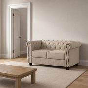 Scale | Beige linen blend Chesterfield loveseat positioned beside an uncropped interior doorway