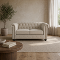 Room | Beige linen blend Chesterfield loveseat with a diamond-tufted back and bronze nailhead arms in a warm sand living room