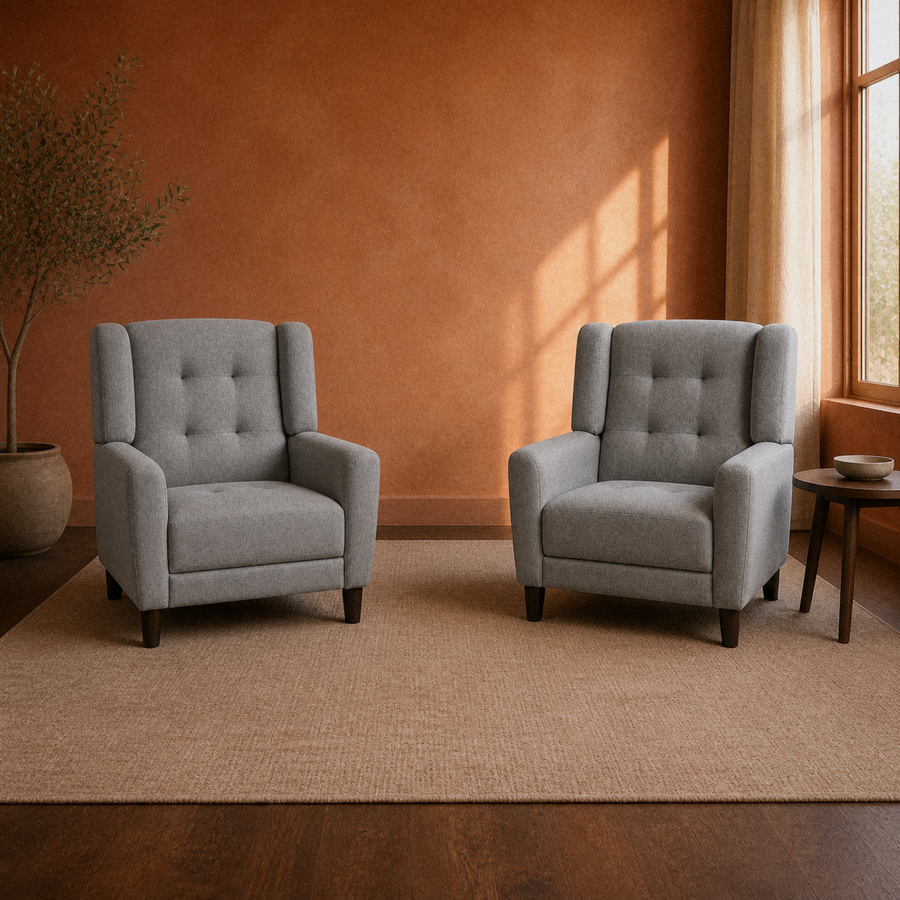Clay room | two matching light gray armchairs on a plain oatmeal rug under warm side light