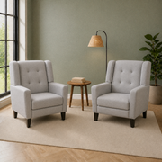 Sage room | two matching light gray armchairs in a sage green living room with a left window