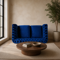 Room | Navy-blue velvet button-tufted rolled-arm loveseat in a warm stone living room with a dark-oak coffee table