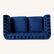 Front | Navy-blue velvet button-tufted rolled-arm loveseat on a clean warm-white studio ground