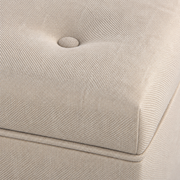 Upholstery close-up | Beige woven polyester with fabric-covered button tuft and tone-on-tone lid seam