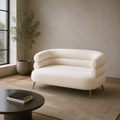 In a room | cream-beige velvet loveseat in a greige loft with a black-framed window and plant