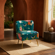 Terracotta room | teal-blue floral velvet armless slipper chair on a plain sand rug beside a dark stone table
