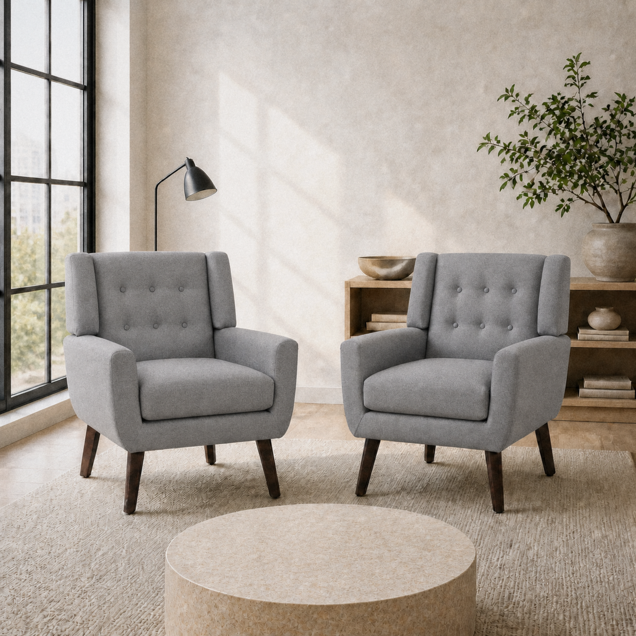 Cool city room | two gray tufted armchairs on a plain cream rug beside a black-framed window and low round table