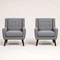 Front | pair of gray tufted armchairs straight on against a warm white studio sweep with six-button backs and dark splayed legs