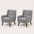 Studio angle | pair of gray tufted armchairs from a left-front three-quarter view on a warm white sweep
