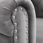 Detail | Extreme close-up of silver nailhead trim set into the light gray velvet rolled arm