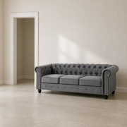 Scale | Light gray velvet Chesterfield sofa beside a full-height painted doorway for size reference