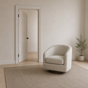 In scale | oatmeal swivel chair beside a full-height open doorway in a warm white room