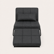 Front | front studio view of the dark charcoal convertible chaise reclined with its matching ottoman cushion and bolster pillow