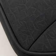 Texture | close-up of the dark charcoal woven upholstery, tonal linear motif, stitched seam, and black piping