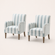 Studio | three-quarter studio view of the two arched striped armchairs showing their side depth and turned legs
