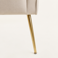 Gold leg close-up | Splayed gold metal leg with beige velvet upholstery