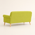 Studio side | vivid lime-green loveseat from the rear left showing the upholstered back and birch legs