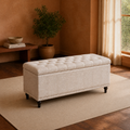 Terracotta living room | warm beige upholstered storage ottoman with a tufted lid, channel stitching and dark turned legs