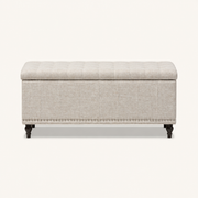 Studio front | warm beige patterned polyester storage ottoman with tufted lid, channel stitching, silver nailhead trim and dark turned legs