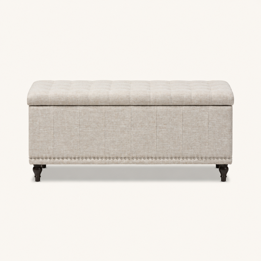 Studio front | warm beige patterned polyester storage ottoman with tufted lid, channel stitching, silver nailhead trim and dark turned legs