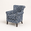 Angle | three-quarter studio view showing the chair depth, patterned side panel, nailhead trim, and wood legs