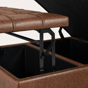 Hardware detail | close view of black metal lift hinges, spring, black-lined storage, and brown faux leather lid