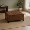 Room | closed umber-brown faux leather ottoman on a plain oatmeal rug in a sage-green living room