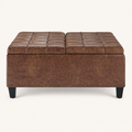 Studio front | square umber-brown faux leather ottoman with two tufted lid panels and four tapered dark legs on a warm-white ground