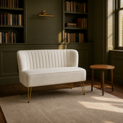 In a room | ivory velvet channel-tufted armless loveseat with gold hairpin legs in a deep olive library room