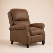 Studio three-quarter | brown faux-leather push-back recliner showing its side depth, padded back cushions, rolled arms, nailhead trim, and black bun feet