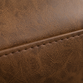 Texture macro | close view of mottled brown faux-leather surface and a stitched seam