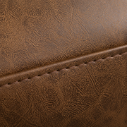 Texture macro | close view of mottled brown faux-leather surface and a stitched seam