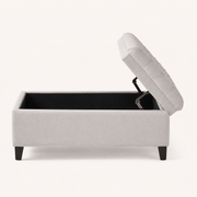 Open | side studio view of the light gray polyester storage ottoman with its flip top open, black-lined storage cavity, dark metal lid support, and plain side panel