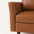Flared arm detail | Mid-brown flared arm, seat cushion, and dark tapered wood leg