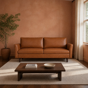Living room | Mid-brown faux leather sofa in a terracotta-walled room with a walnut coffee table