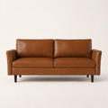 Front | Mid-brown faux leather sofa with flared arms and two loose back cushions on a clean studio ground