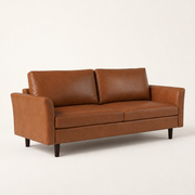 Studio angle | Three-quarter studio view of the mid-brown faux leather sofa with flared arms and tapered legs