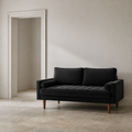 Scale | black velvet sofa beside a full-height interior doorway on a stone floor