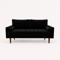 Front | front studio view of black velvet sofa with a square-tufted bench cushion, two cylindrical bolsters, and tapered brown wood legs