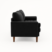 Side | left-side studio profile of black velvet sofa showing the square arm, back cushions, tufted bench, and brown wood legs