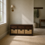 In a room | dark cherry wood storage bench with three drawers and three woven baskets in a softly lit entry