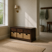 Angle | three-quarter view of dark cherry storage bench with drawers and woven baskets in a pale olive entry