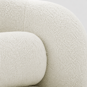 Material close-up | cream white looped boucle upholstery on the chair's rounded arm and bolster