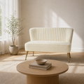 Living room | Ivory velvet armless loveseat with a channel-tufted back and gold metal legs in a warm white room