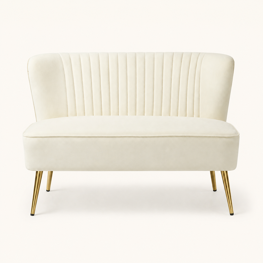 Front | Ivory velvet armless loveseat with channel tufting and four gold metal legs on a clean studio ground