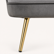 Gold leg detail | Close view of one tapered gold metal leg, black foot tip, and seat attachment