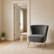 Scale | Grey velvet accent chair beside a full-height doorway in a neutral room