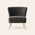 Front | Grey velvet accent chair with a flared channel-tufted back and four tapered gold legs on a clean studio ground