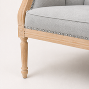 Wood detail | Carved birch corner block, turned front leg, black seat edge, and silver nailhead trim